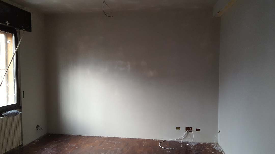 Lavori di ristrutturazione edilizia Interno di una stanza in fase di ristrutturazione con pareti da dipingere.
