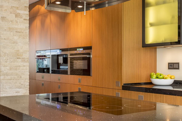 Cucina moderna in legno e pietra Cucina moderna con elettrodomestici integrati e superfici in pietra naturale.