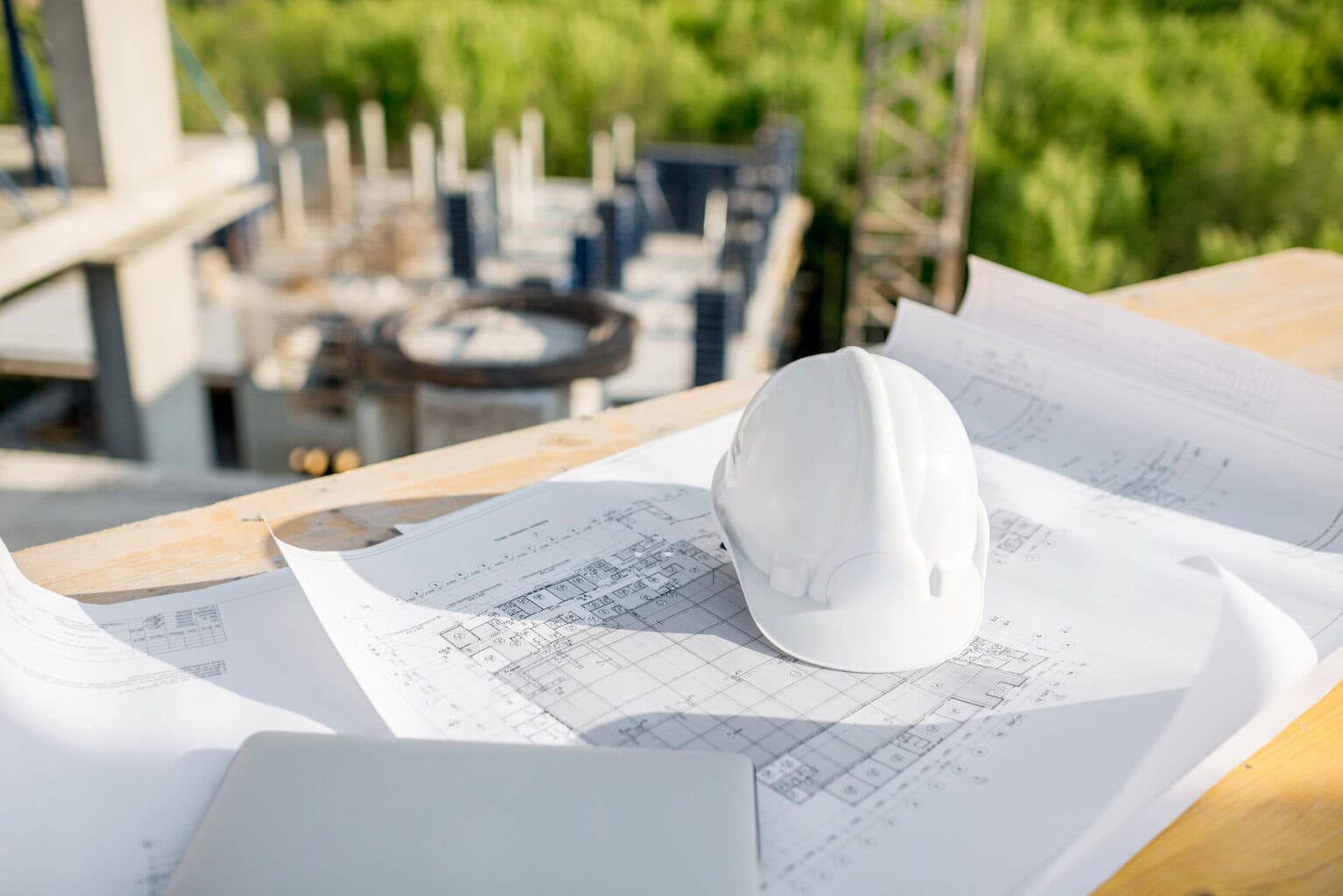 Progetto edilizio con casco e planimetrie Progetto edilizio con casco, planimetrie e strumenti di lavoro edile.